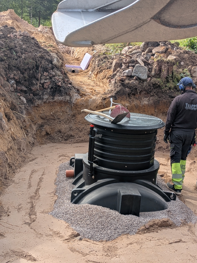 Kringfyllning av avloppstank med makadam på sandbädd